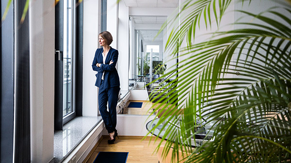 Frau steht vor dem Fenster und schaut raus